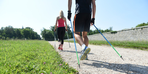 jeune couple pratiquant la marche nordique