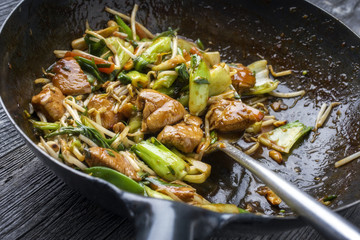 Traditional stir fried Chicken Gung Bao with Vegetable as close-up in Wok.