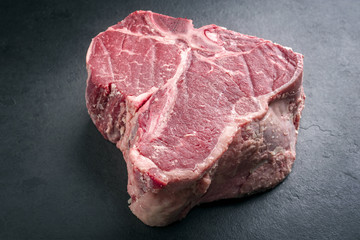 Rohes dry aged Wagyu Porterhouse Steak als close-up auf schwarzer Schieferplatte