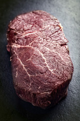 Dry aged raw Wagyu Point Steak as close-up on a slate