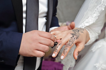 couple mariage oriental avec mains dessinée au henné passant la bague au doigt