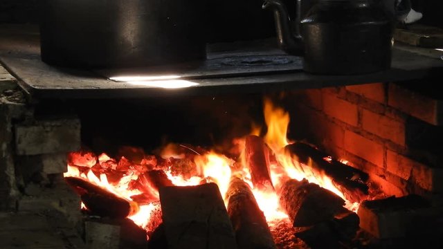 4k close up of the rustic Brazilian farmhouse wood burning stove. Large pans on large open fronted iron wood burning stove