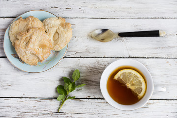 Cup of green tea with lemon and almond biscuits