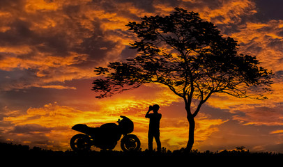 Silhouette, Men Take a photo of the sunset  gold color and motorbike Big Bike, beautiful.