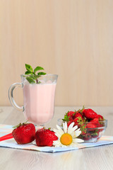 Glass of yogurt  with mint and fresh strawberries on the table