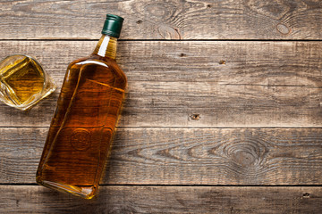 Bouteille et verre de whisky sur planches de bois