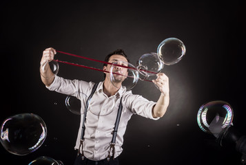 Artist blowing many soap bubbles from his hands. Bubble show studio concept.