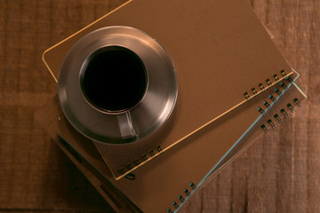 coffee Cup with spoon and biscuits on the background of notebooks