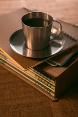 coffee Cup with cookies is on the stack of notebooks