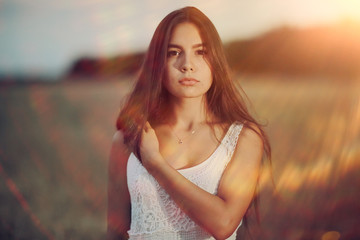 Fototapeta premium Young glamorous model posing in a field wheat