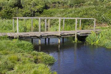 The remote wooden foot bridge on the Solent Way, Southampton Water at the end of the Hook Lane bridle path near Titchfield Common in Hampshire