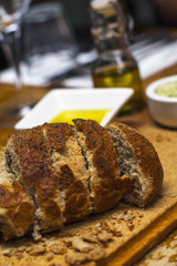 Fresh brown bread on the wooden table with oil and butter