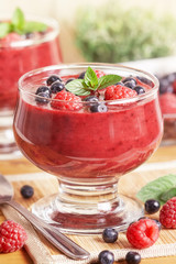Blueberries and raspberries smoothie served on wooden background