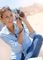 Cheerful girl taking pictures of the beach, tourist area