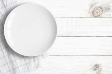 Top view of empty food plate put on tablecloth and wood table., All white object with copy space.