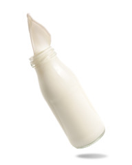 Milk splash out of bottle isolated on white background.