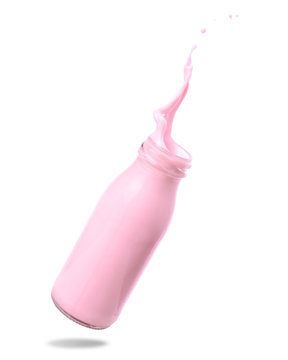 Strawberry Milk Splash Out Of Bottle Isolated On White Background.