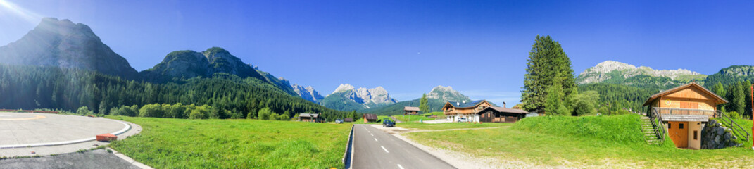 Fototapeta na wymiar Huts surrounded by high mountains, italian alps