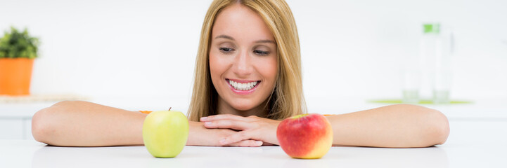 attraktive blonde frau lächelt obst an