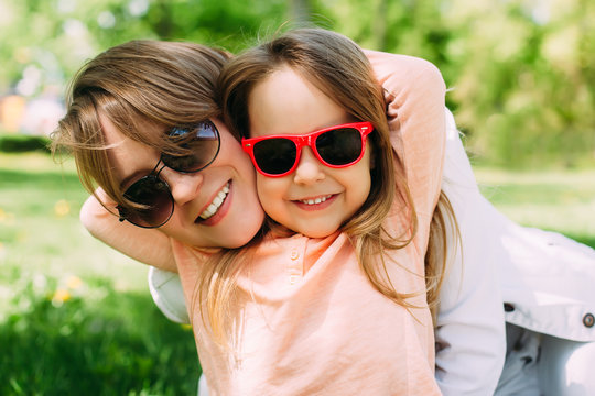 Summer. Portrait of mother with daughter having fun. Woman and girl child kid in sunglasses.