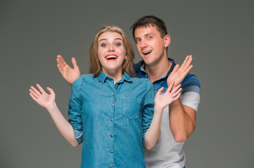 Portrait of a young couple standing against gray background