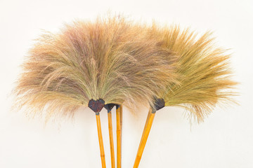 Grass broom on white wall