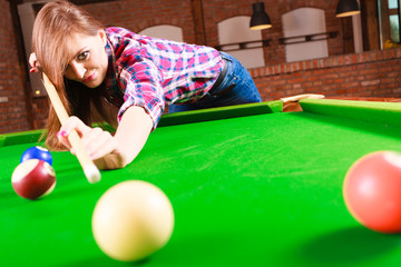 Fototapeta premium Young woman playing billiard.