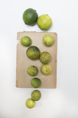 Herbarium der Früchte
Grüne Limetten auf braunem Papier