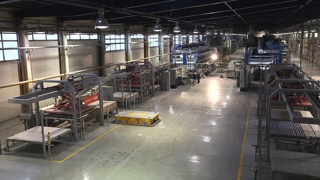 Industrial interior, production of ceramic tiles, modern factory interior. Autonomous mobile robots transport products in a large modern factory.