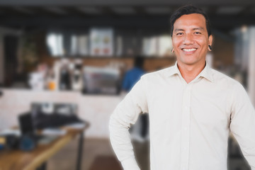 Successful small business owner standing at his cafe coffee shop. young male entrepreneur smiling in front of his restaurant feeling confident