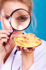 Doctor with magnifying glass examining sweet food