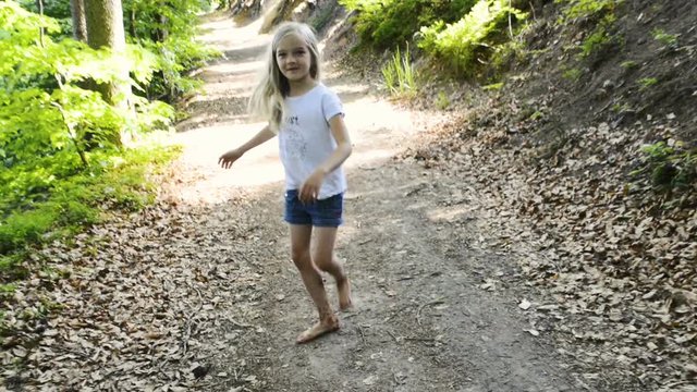 A girl walking barefoot on a forest path