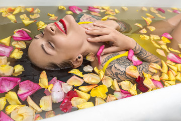 Obraz na płótnie Canvas Tattooed girl posing in bath