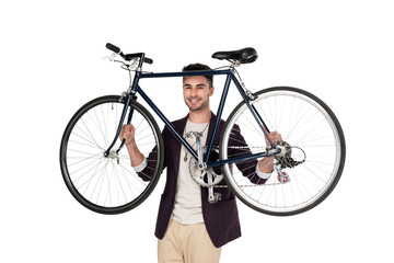 Smiling stylish young man holding bicycle and looking at camera