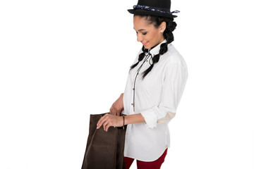 Beautiful young woman in hat holding leather bag and smiling