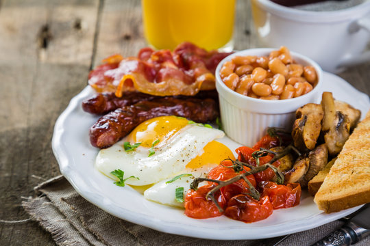 Full english breakfast - eggs, bacon, beans, toast, coffee and juice