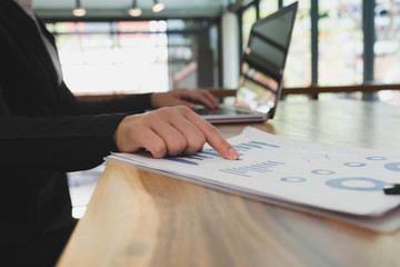 businesswoman using laptop computer at workplace. young female entrepreneur woman working with business document at office. analytic financial accounting market chart and graph plan report.
