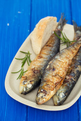 grilled sardines with bread on dish
