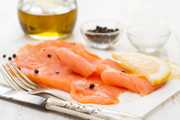 smoked salmon with lemon on white dish