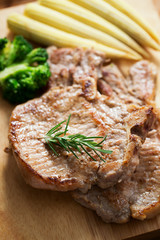 grilled pork chop with vegetable on wooden board