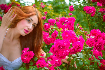 Obraz na płótnie Canvas Beautiful and attractive redhead lady with colorful vintage make up. She rest on weekend in garden. Woman have a vacation and spend good time