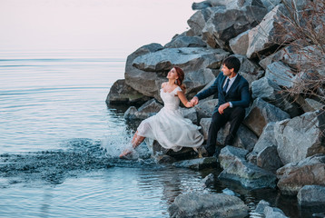 Stylish wedding on the river bank. Walk of lovers at sunset. A beautiful love story. Film colors.