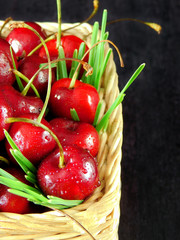 Close-up of cherries with drops in a wicker basket