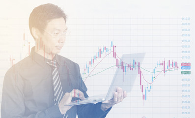 Businessman using laptop with business charts and graphs