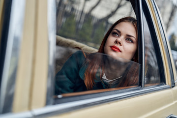 Fototapeta na wymiar Woman dreams, woman sits in the car with an open window