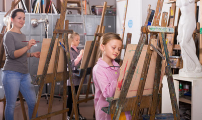 schoolgirls diligently training their painting skills during class at art studio