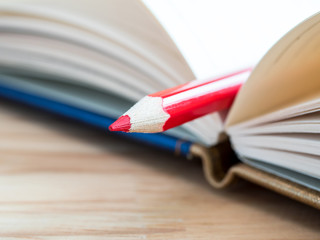 Red color pencil stand on blank notebook 1