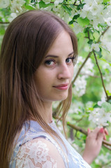 Fototapeta premium Girl posing against a background of flowering trees / Photographed in Russia, in the city of Orenburg