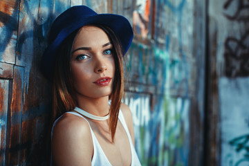 Portrait of a young attractive woman with blue eyes and hat