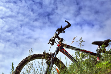 The bike on the background of sky and grass, view from bottom